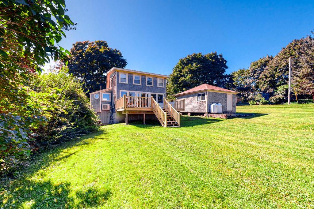 duży dziedziniec z domem i małą szopą w obiekcie Lupine Cottage w mieście Owls Head