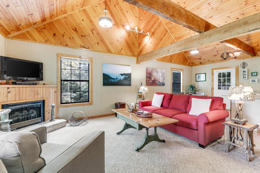a living room with a red couch and a fireplace at Fresh Ayres Getaway in Banner Elk