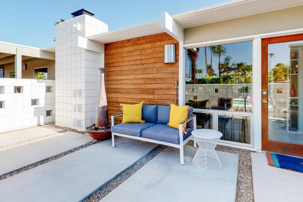 eine Veranda mit einem blauen Sofa und gelben Kissen in der Unterkunft Serenity in Sunmor Permit# 4761 in Palm Springs