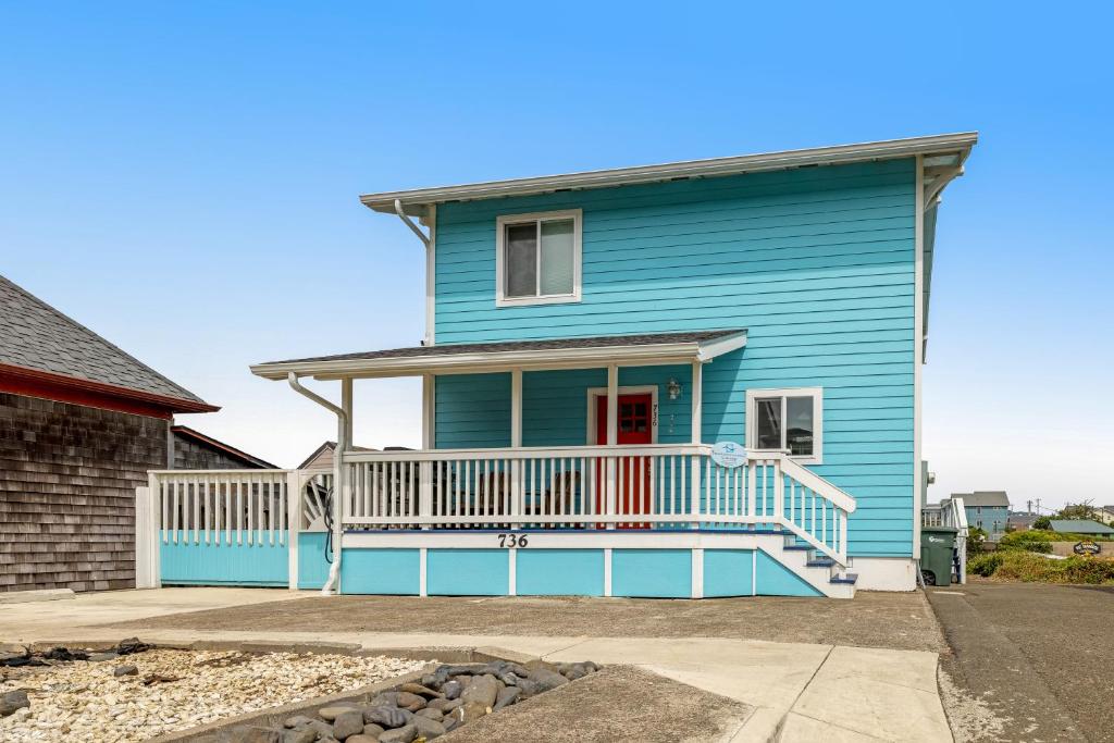 a blue house with a white deck at Sea Mist Cottage in Newport