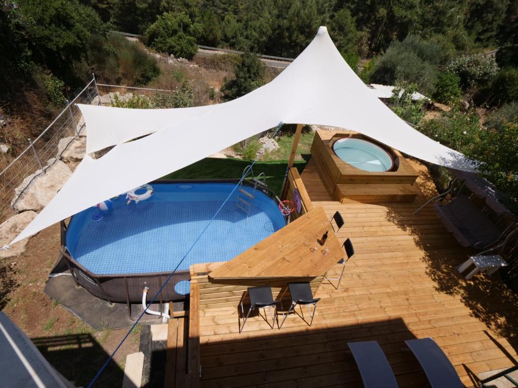 ein weißes Zelt über einem Pool mit Stühlen in der Unterkunft Oren's place - perfect for families & friend's in Kefar Weradim