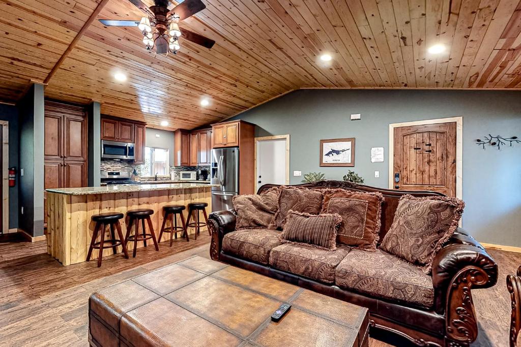 a living room with a couch and a kitchen at Country Club Cabin in Big Bear City