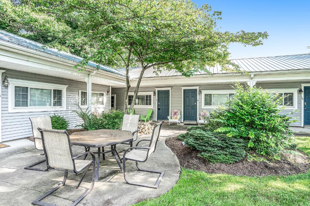 a patio with a table and chairs in front of a house at Arrowhead Resort in Saugatuck