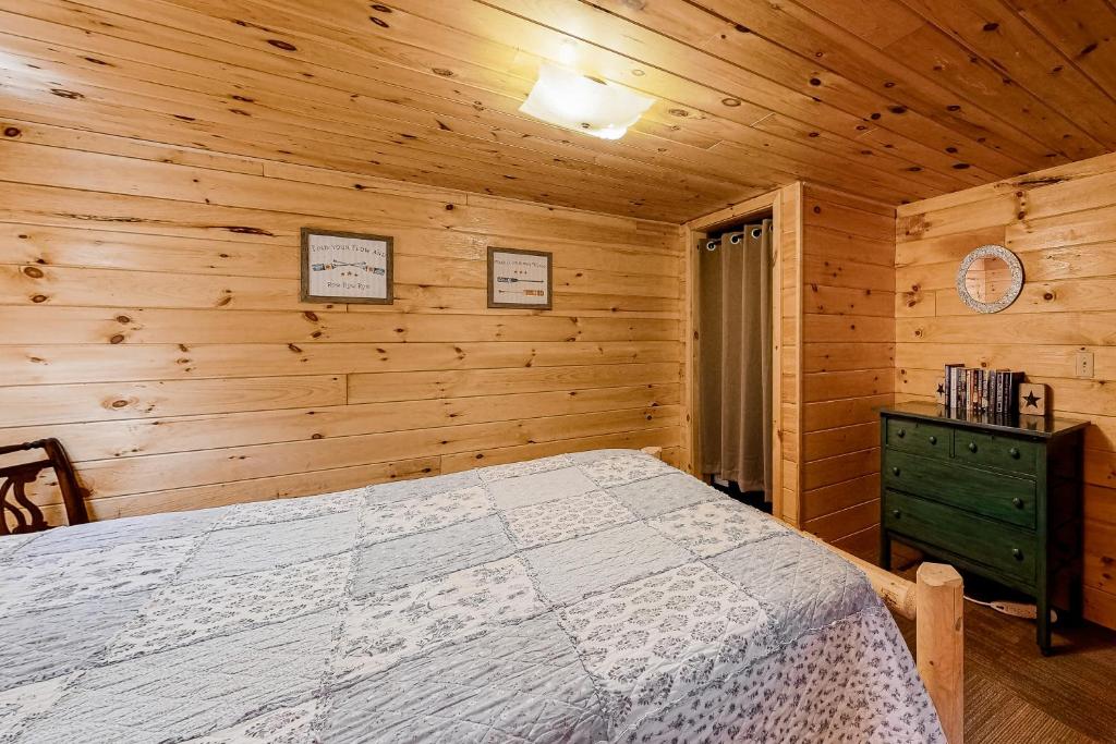 a bedroom with a bed and a wooden wall at The Pinecone in Winthrop