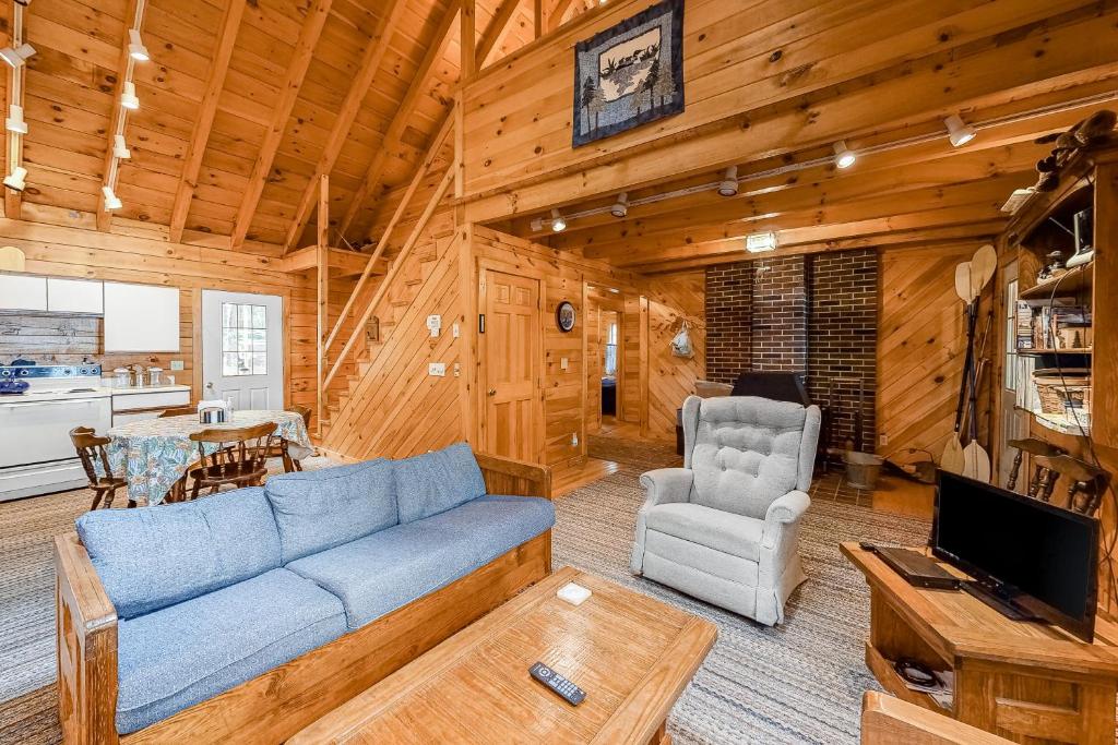 a living room with a blue couch and a table at Lake View Cottage in Leeds