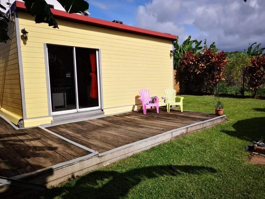 2 chaises assises sur une terrasse à côté d'une maison dans l'établissement La case bignone, à Saint-André