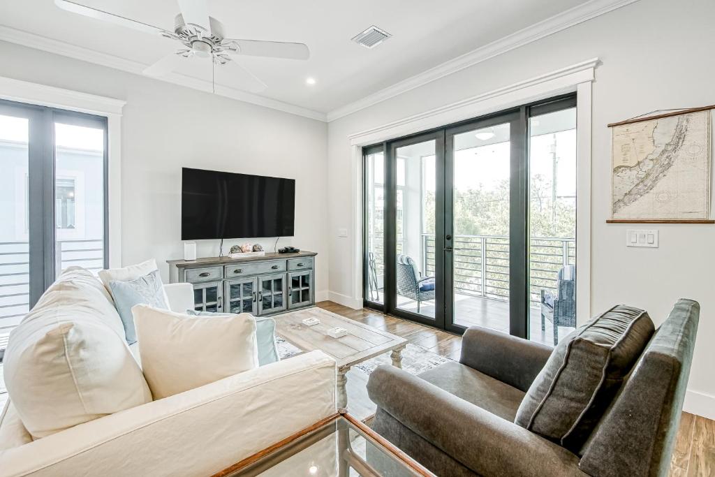 a living room with two couches and a tv at Pure Aquamarine in Key Largo