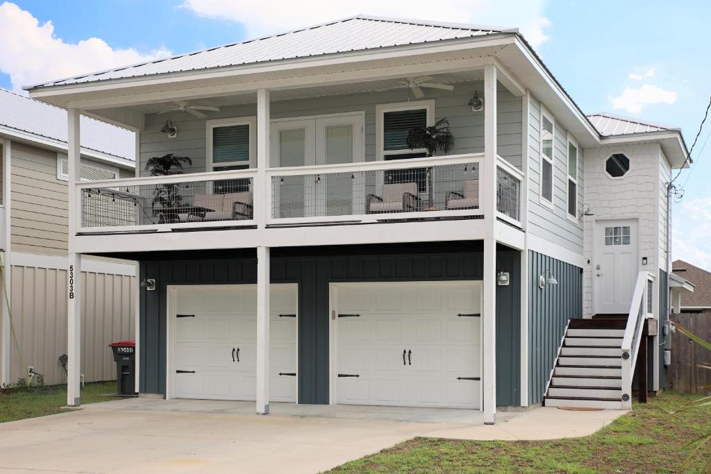 a house with two garage doors and a balcony at Blue Haven in Panama City Beach