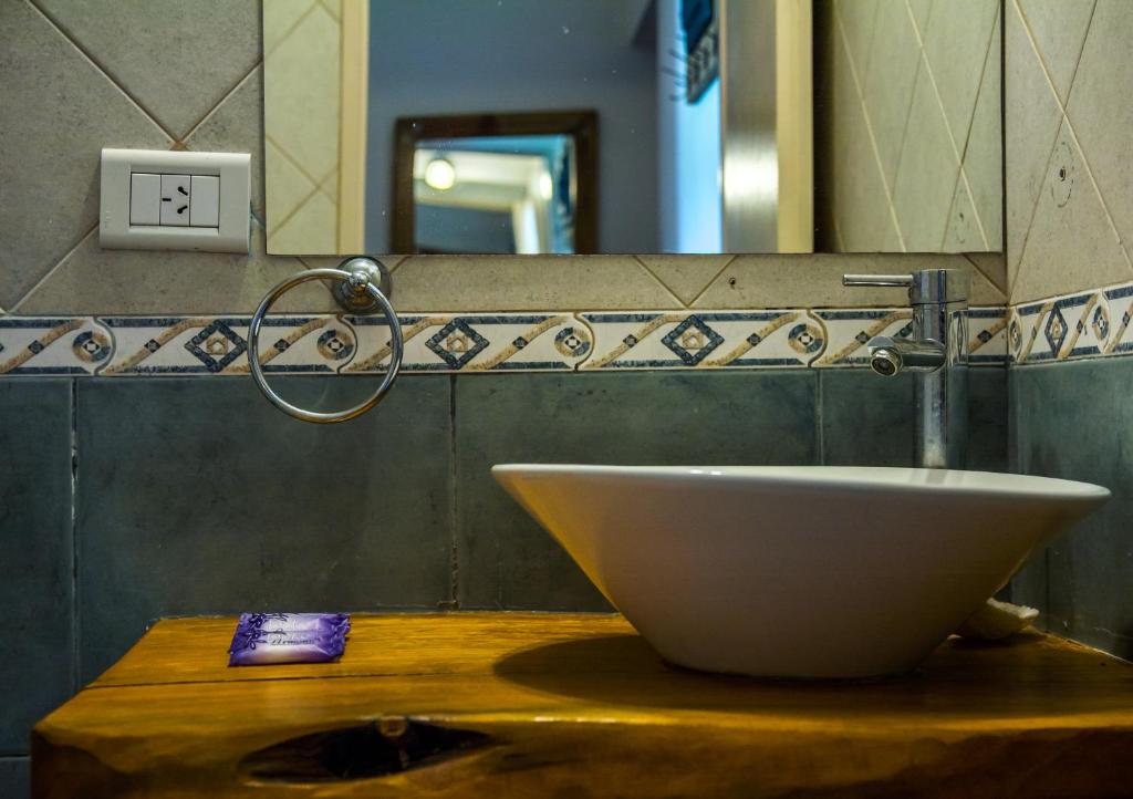 a bathroom with a bowl sink on a wooden counter at Casas Serranas Margaritas in Sierra de la Ventana