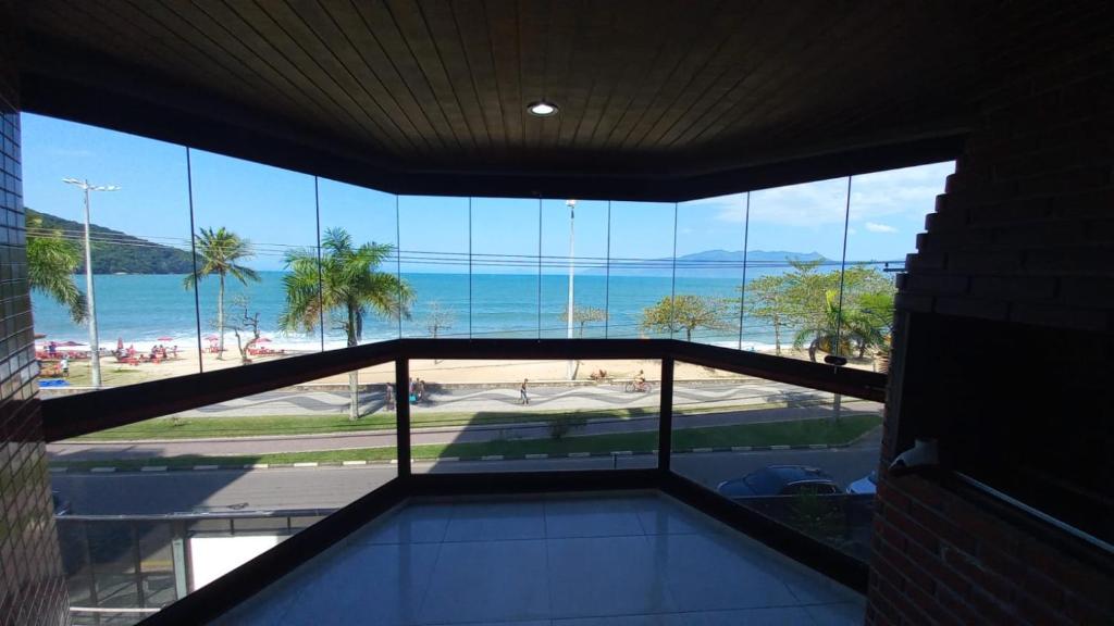 vistas al océano desde un edificio con ventanas en Apartamento San Martin, en Caraguatatuba