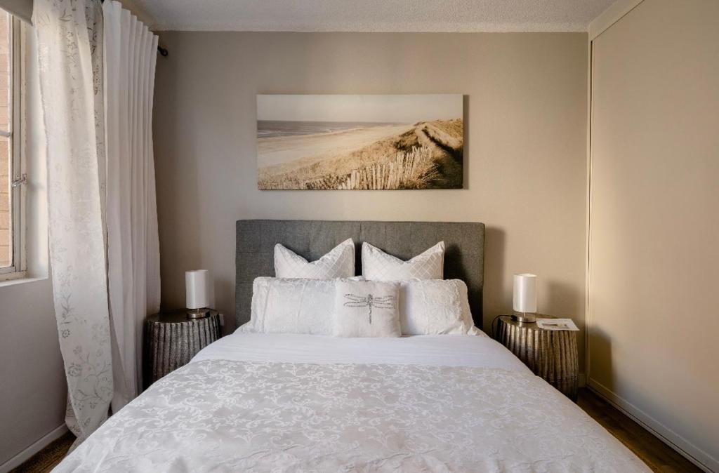 - une chambre avec un grand lit et des oreillers blancs dans l'établissement Top Mosman Location, à Sydney