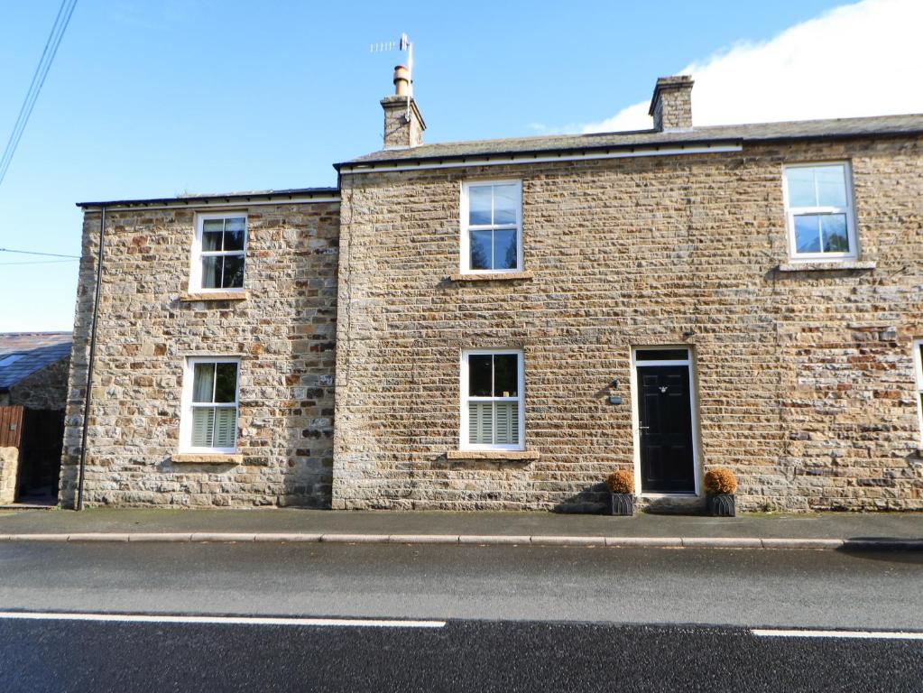 a brick building on the side of a street at Tree Tops in Alston