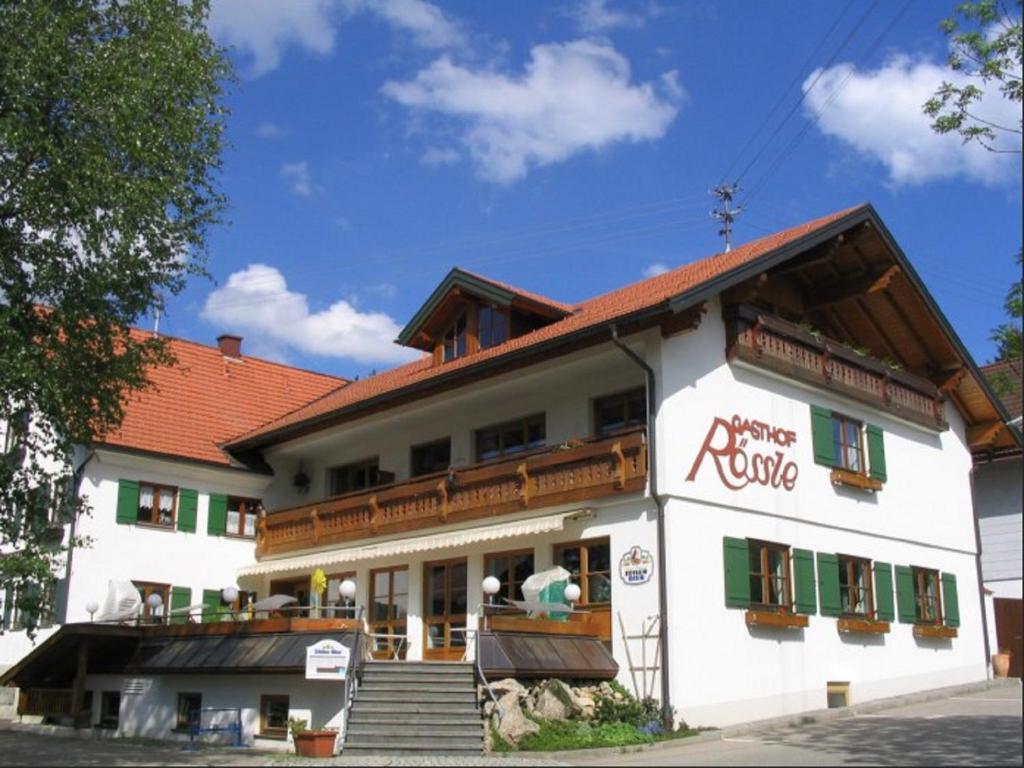 a large white building with a red roof at Gasthof Rössle in Sulzberg