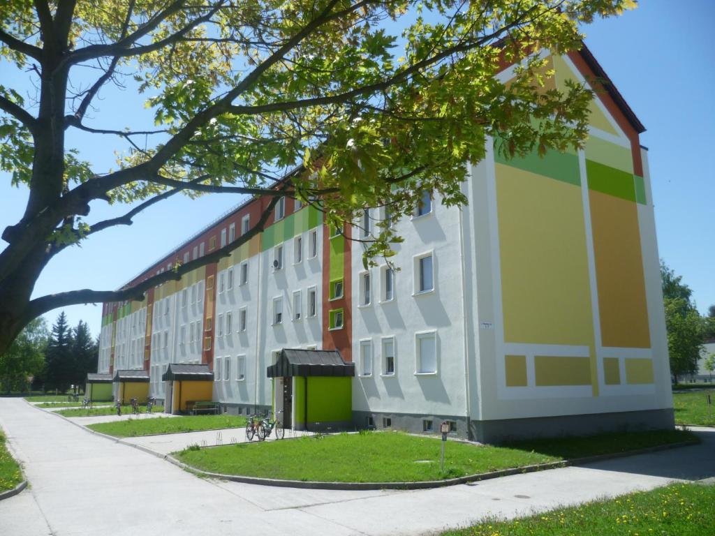 un edificio de apartamentos con un árbol en el primer plano en Gästewohnung in Niesky en Niesky