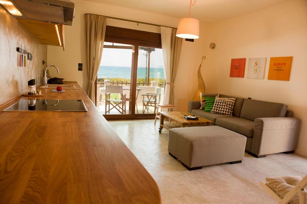 ein Wohnzimmer mit einem Sofa und einem Tisch in der Unterkunft Horizonte Seafront Suites in Kissamos