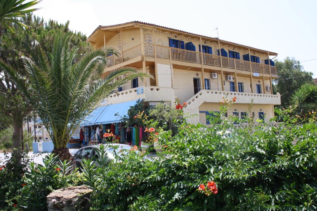 a building with a palm tree in front of it at Ilios in Kalamaki