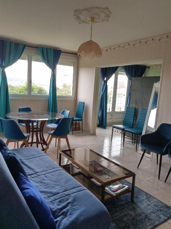 un salon avec un canapé, une table et des chaises dans l'établissement Bleu d'Arques Appartement lumineux et calme, à Dieppe