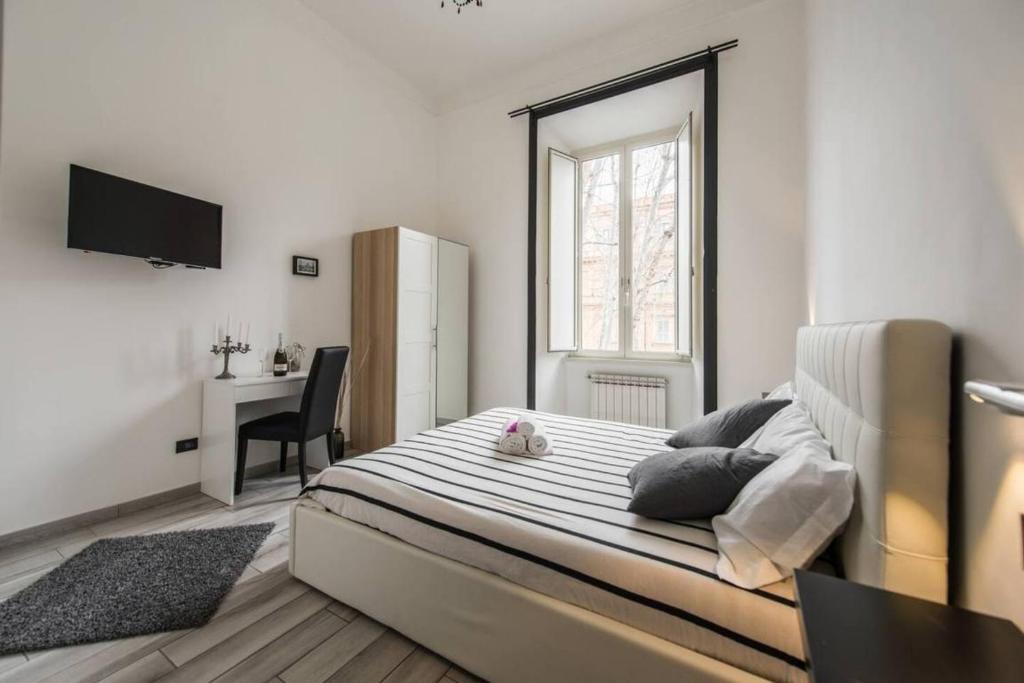 una camera con letto, scrivania e finestra di Lazy Gio Guest House a Roma