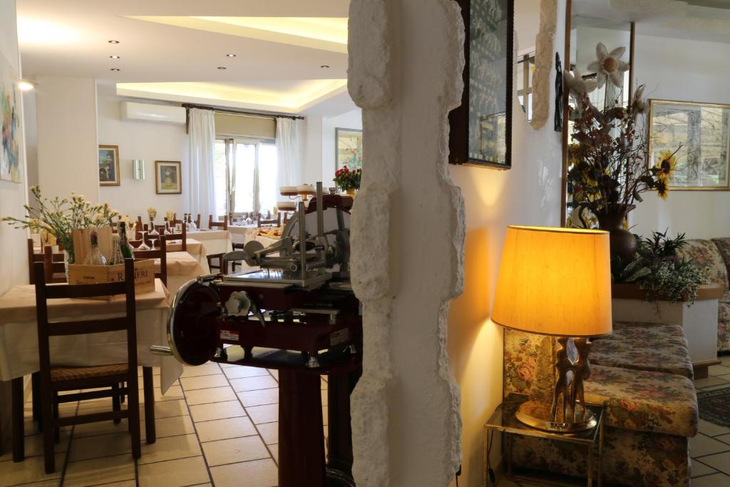 a living room with a table and a lamp at Hotel Berna in Eraclea Mare