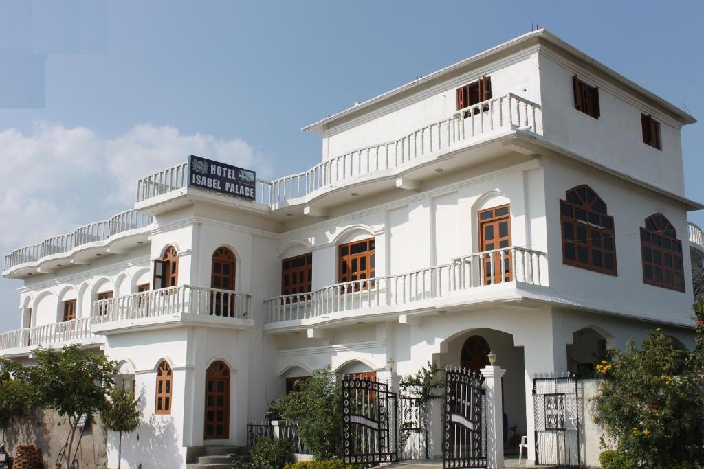 a white building with balconies on it at Hotel isabel Palace in Khajurāho