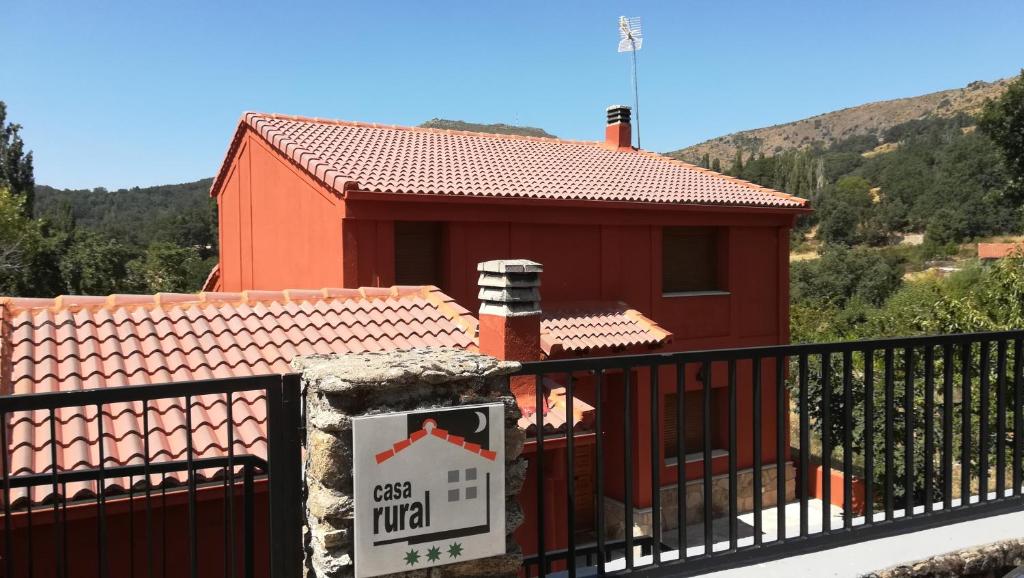 un piccolo edificio rosso con un cartello di fronte di Casa Rural Las Canales a Zapardiel de la Ribera
