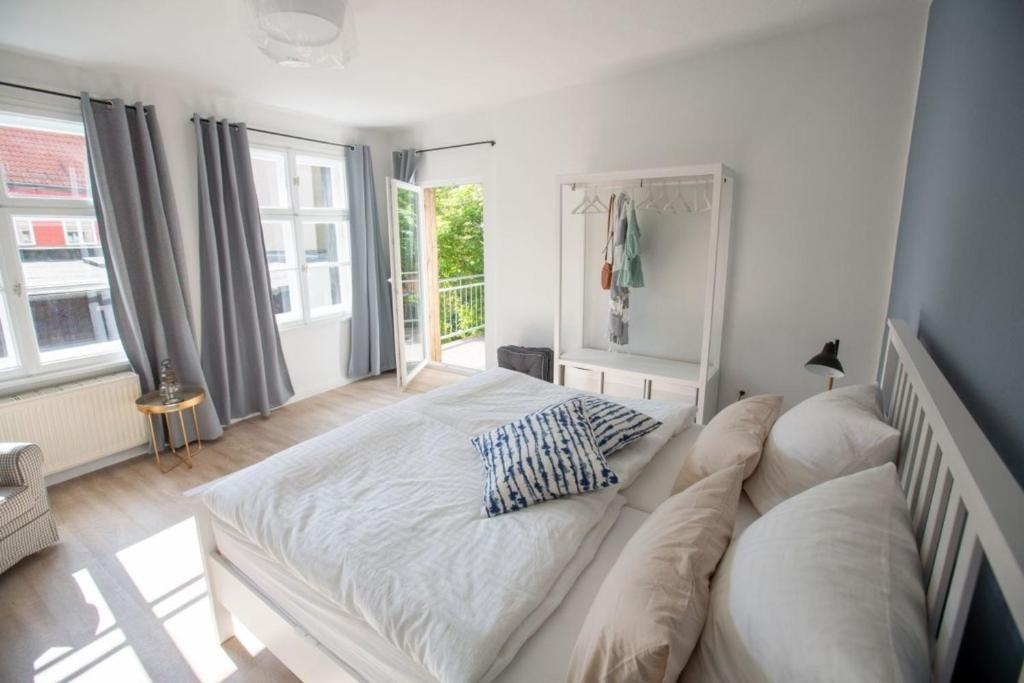 a large white bed in a room with windows at Apartment No4 in Stralsund