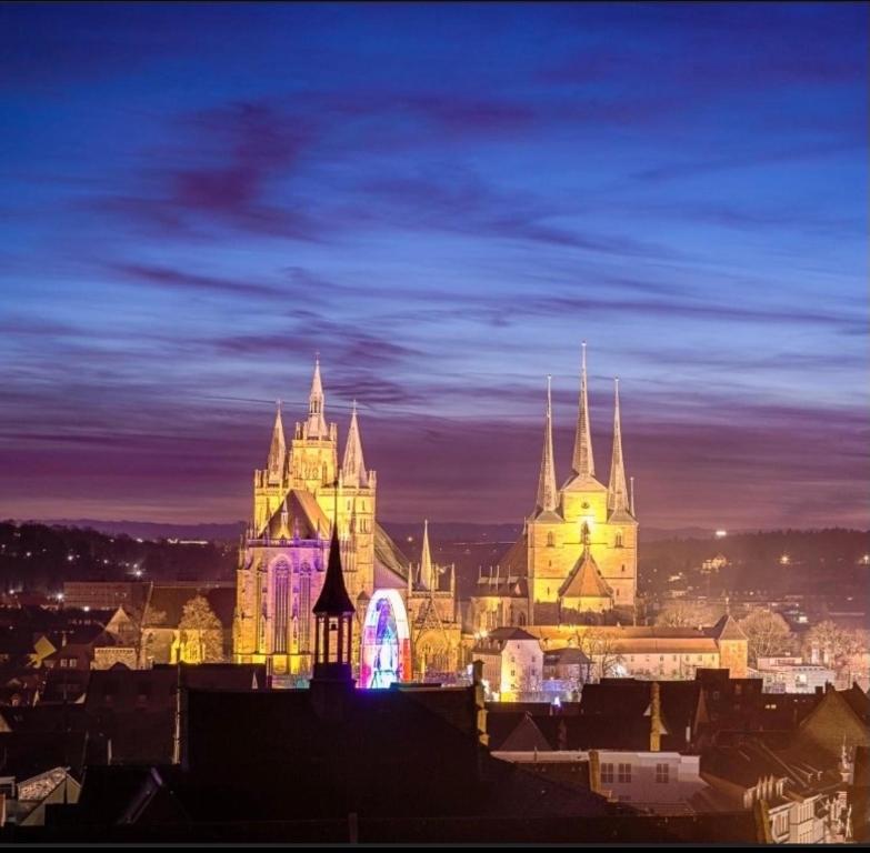 una ciudad iluminada por la noche con un castillo en Markthof am Dom, en Erfurt