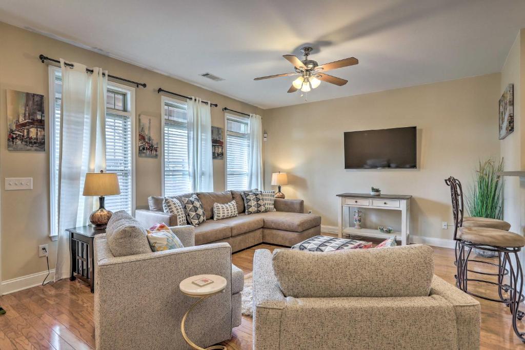 a living room with a couch and a ceiling fan at Macon Townhome with Patio, 5 Miles to Downtown! in Macon