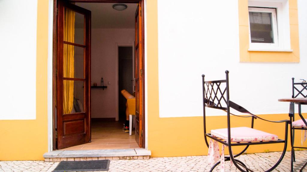an open door of a house with a chair next to it at Breathe In in Zambujeira do Mar
