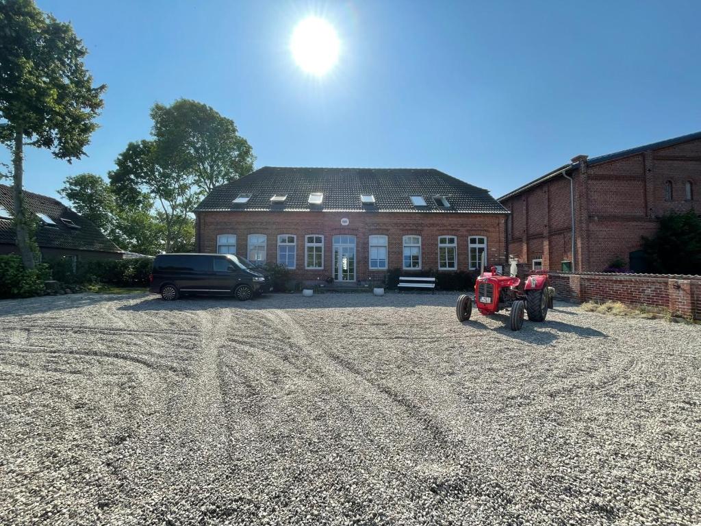 un tractor rojo estacionado frente a un edificio en Ferienvermietung Klakus - a60263 en Fehmarn