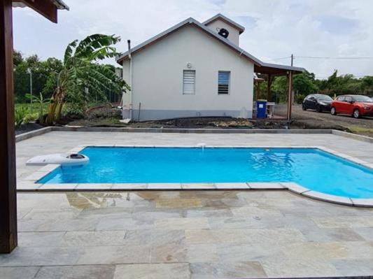 une grande piscine bleue en face d'une maison dans l'établissement KAZ's à l'Anse Maurice, à Gros Cap