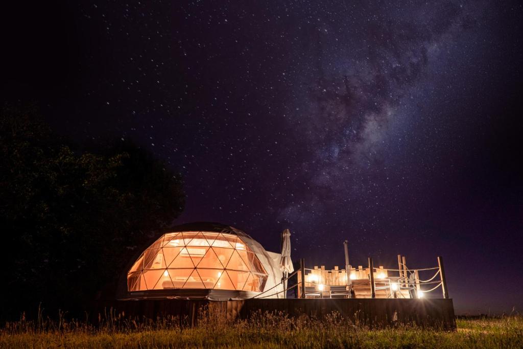 a greenhouse in a field at night with the milky way at Au Champ de l'Insolite in Miers