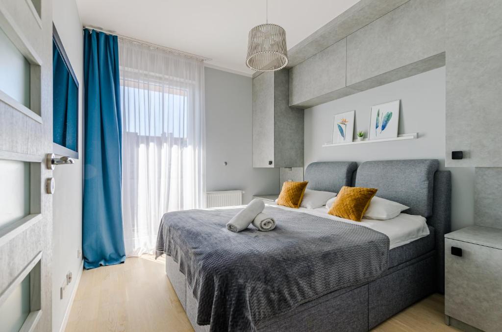 a bedroom with a large bed with a blue blanket at Grobla by Loft Apartments in Gdańsk
