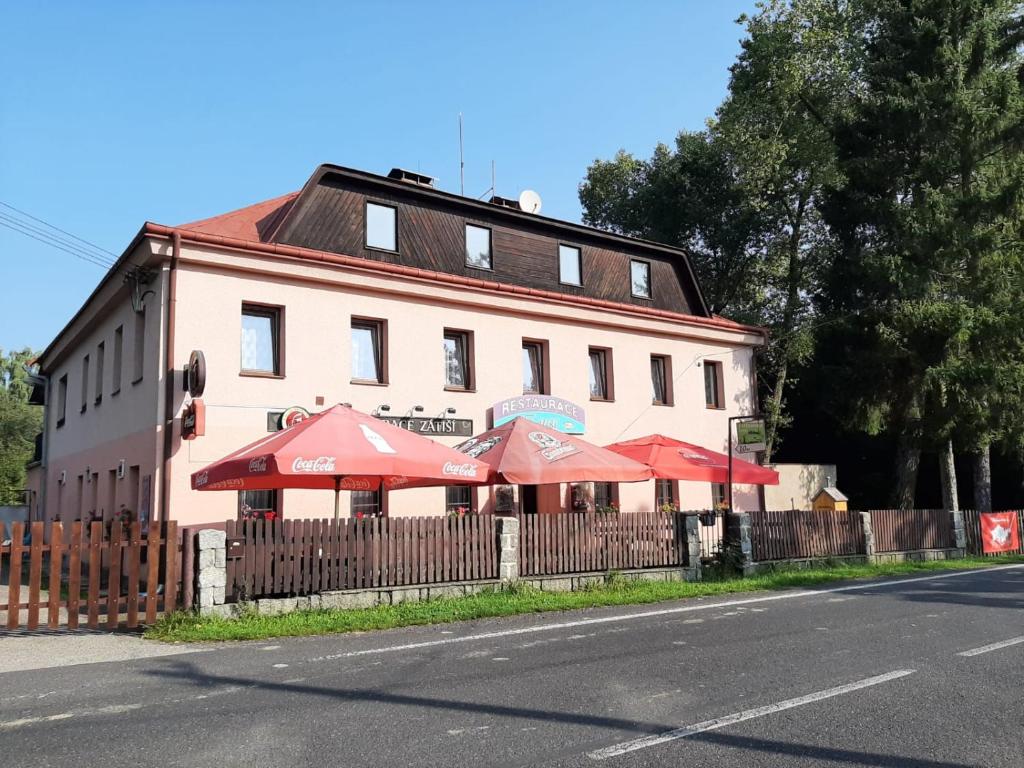 a building with red umbrellas in front of it at Penzion Restaurace Zátiší in Rumburk