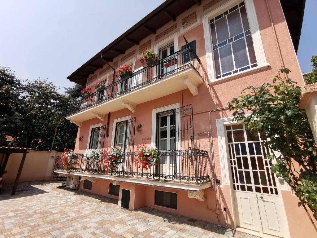 une maison rose avec des fleurs sur les balcons dans l'établissement B&B Ad Quintum Torino, à Collegno