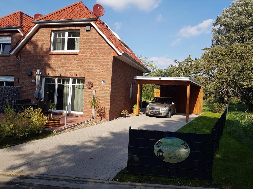 een huis met een auto geparkeerd onder een garage bij harle-casa.ostfriesland in Altfunnixsiel