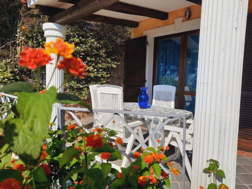 聖特雷莎加盧拉的住宿－La Filetta Alisei，门廊上的桌椅,鲜花盛开
