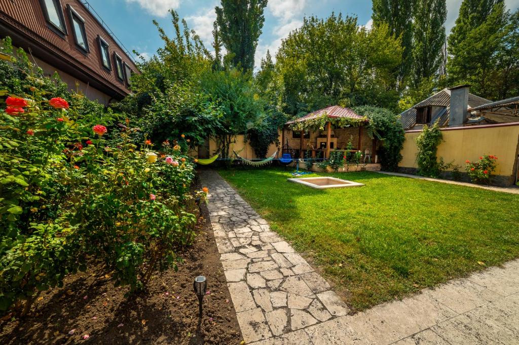 a backyard with a garden and a house at Хостел Friends Пятигорск in Pyatigorsk