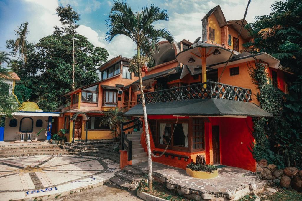 a house with a palm tree in front of it at Kashama Eco Resort & Spa in Santo Domingo de los Colorados