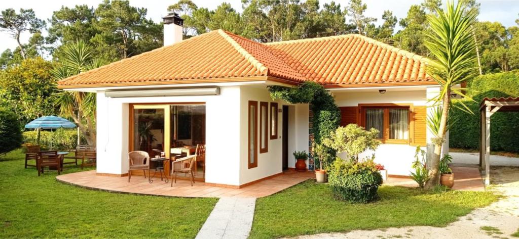 een klein huis met een patio in de tuin bij Casa da Croa in Laxe
