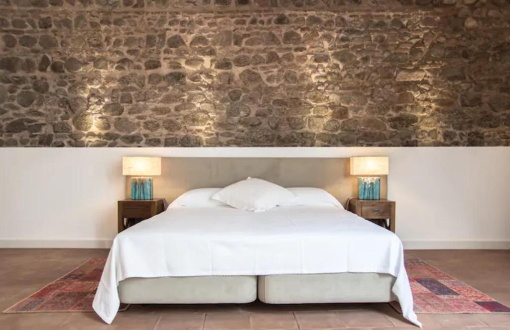 a bedroom with a large white bed with two night stands at Casa do Sembrano in Beja