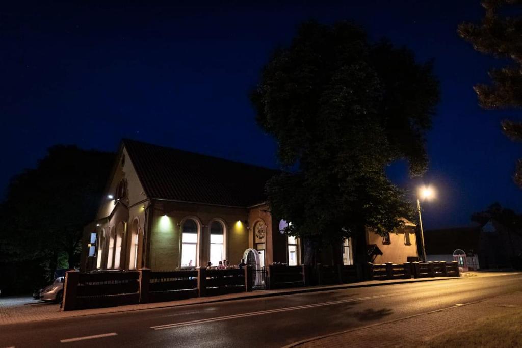 a building on the side of a street at night at Dom Weselny Pod Kasztanem in Lubań