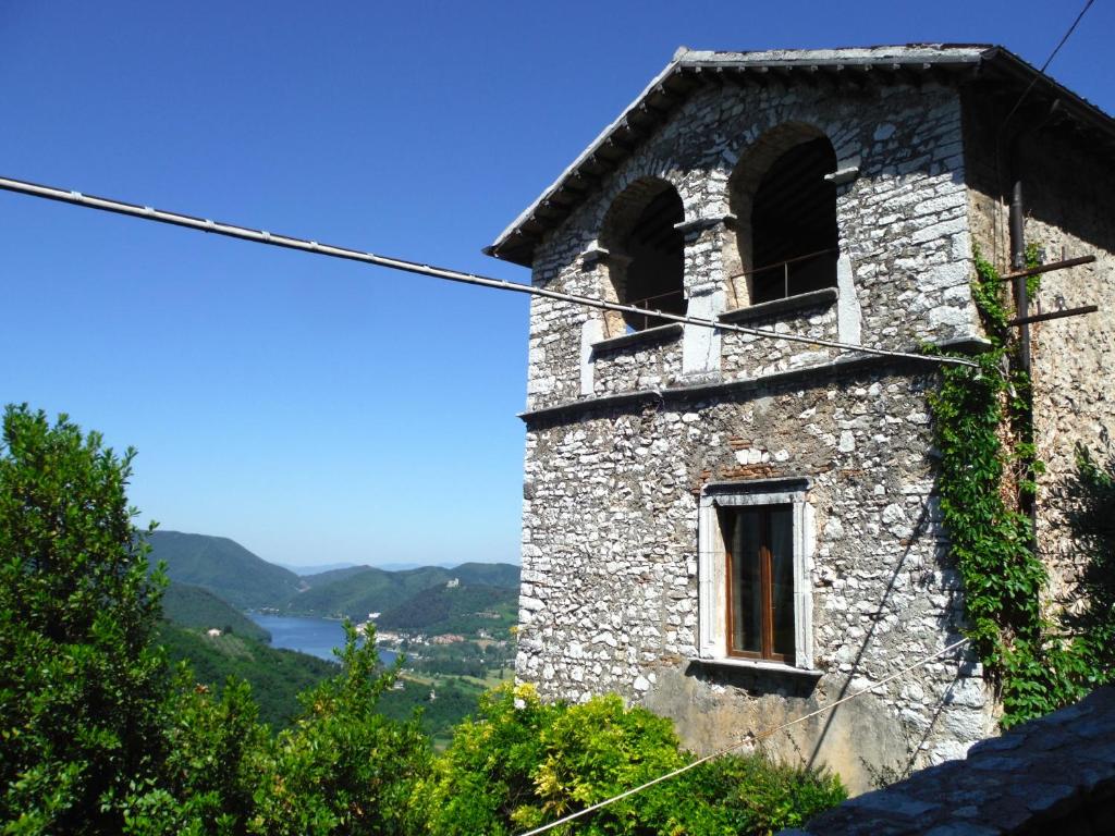 un antiguo edificio de piedra con una ventana en una colina en Casa Due Archi Labro, en Labro
