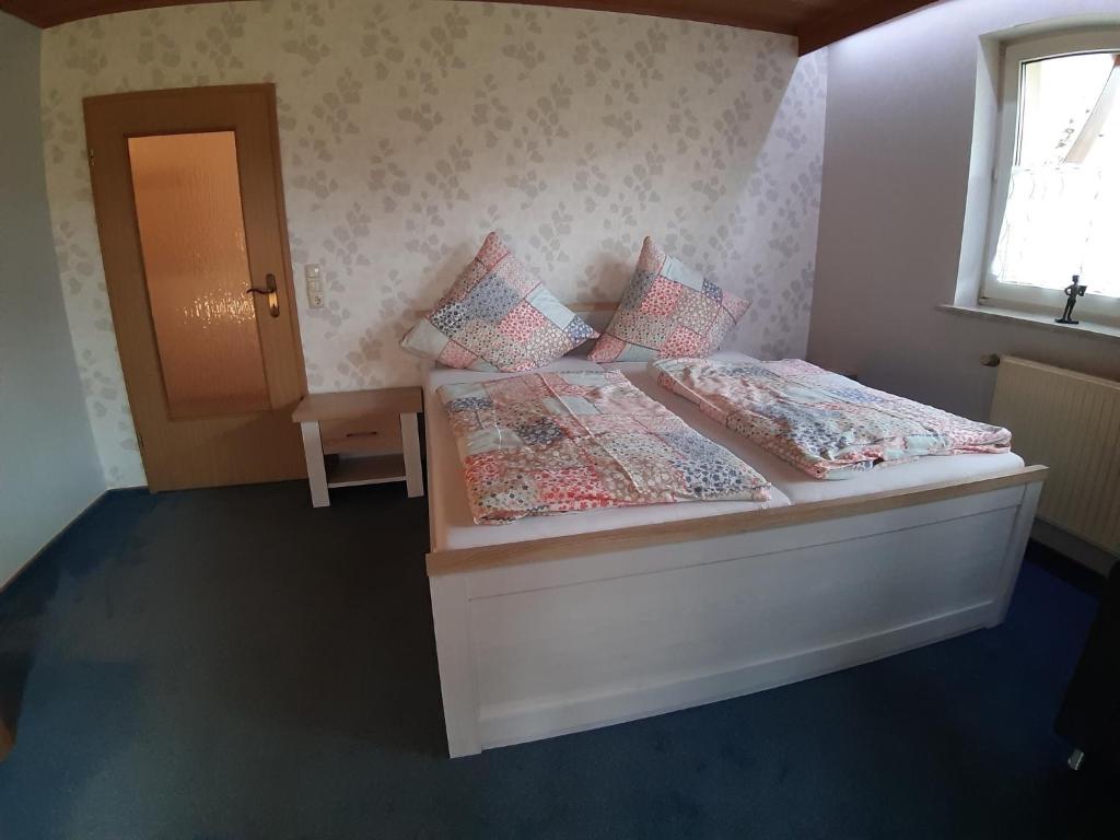 a bedroom with a bed with two pillows and a window at Ferienwohnung Elisabeth in Egloffstein