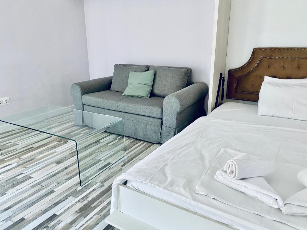 uma sala de estar com uma cama e um sofá em Turquoise and Magenta Apartments em Sófia