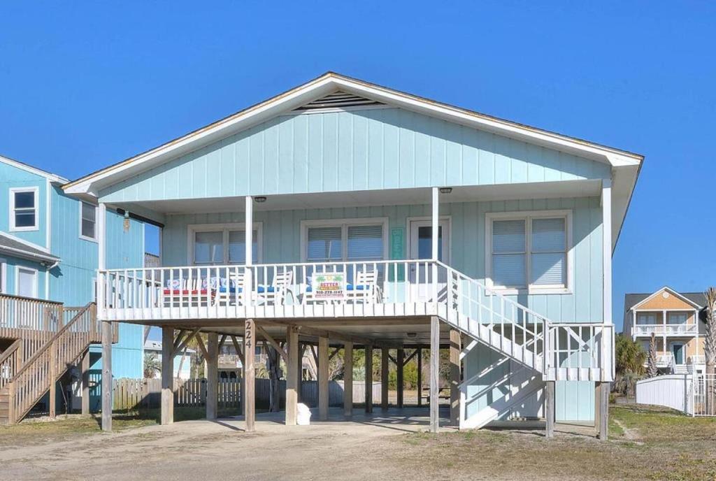 Casa azul con terraza blanca y escaleras en UnCorked, en Oak Island