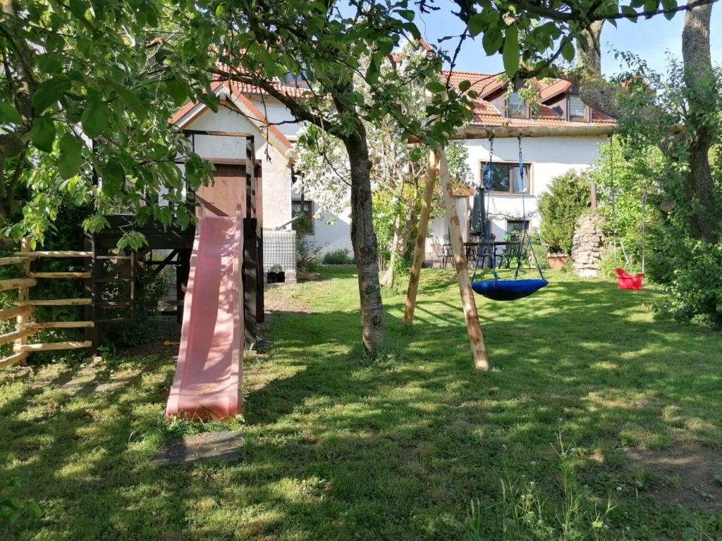 a yard with trees and a swing in front of a house at Knoofs in Schwirzheim