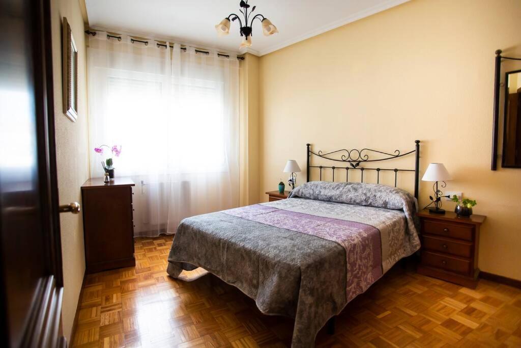 a bedroom with a bed and a large window at Piso luminoso y tranquilo en Ourense (O Couto) in Ourense