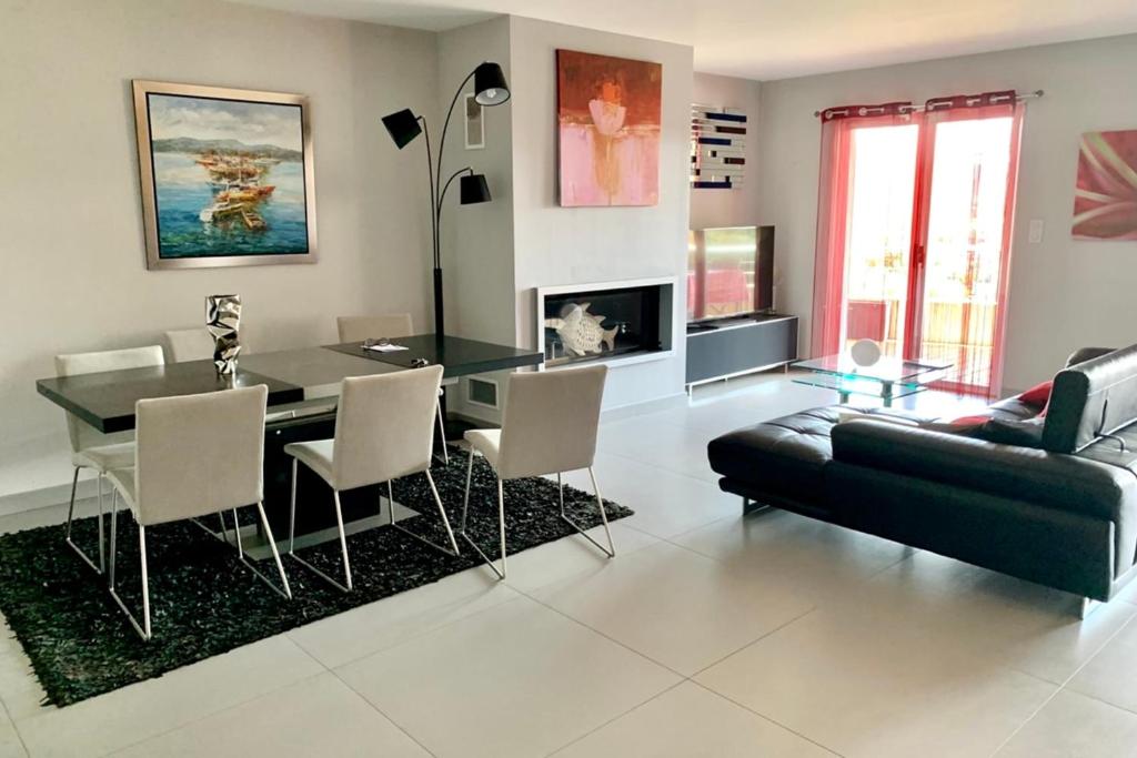 a living room with a dining table and a couch at Elegant Design Apt With Balcony And Pool in Porto-Vecchio