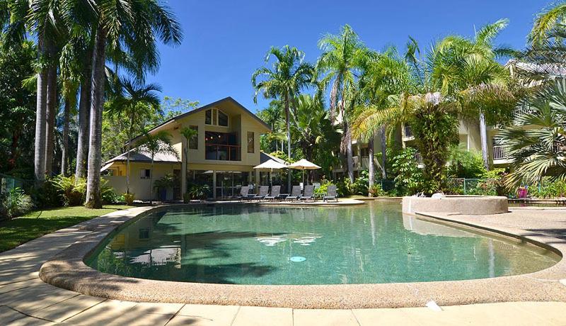 a large swimming pool in front of a house at Port Douglas Sands Resort in Port Douglas